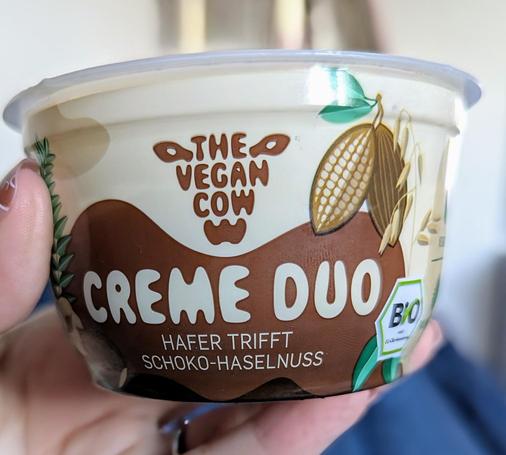 Ein Becher Creme Duo von The vegan Cow. Hafer trifft Haselnuss.