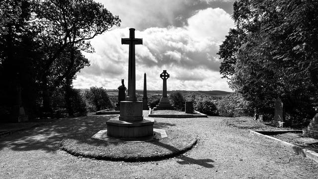 Various tall memorials and gravestones, a couple of which are crosses. There are trees on the left and right and in the distance are hills. It’s all in black and white. Or at least it was when I took the photo - it was all normal and colour when I left it. And indeed when I arrived.