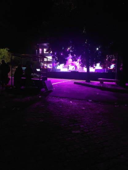 Foto de uma festa de aldeia à noite com um palco e sem plateia