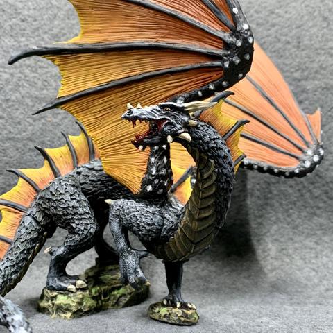 A black dragon with orange and yellow wings like a monarch butterfly. The wings are held upwards, and its tail wraps around its front. It has an open mouth with gore dripping from it.
