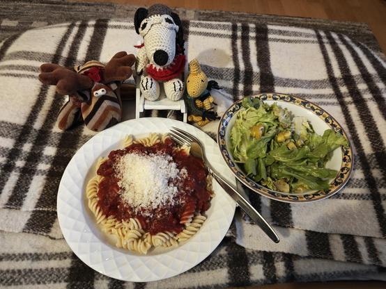 Knelvis, Snoopy und Woodstock fallen über einen Teller voller Nudeln mit Tomatensauce und Parmesan her. Dazu gibt es grünen Salat.
