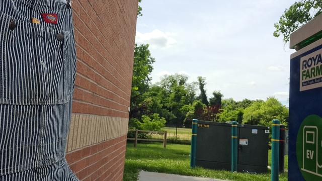Selfie with part of me left, grass + trees center and an EV charging station right.