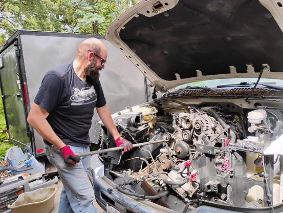 Chuck using a 5' helper to back out an engine mount bolt as he pulls the LR4 V8 engine from his truck.