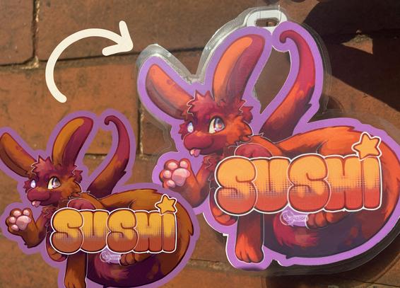 a printed and laminted convention badge featuring an orange and purple amphimorpho character blepping and waving happily, wrapping their long body around the name 'Sushi'