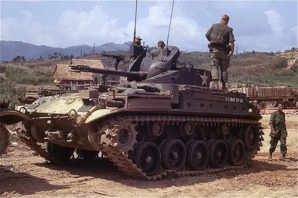 The image depicts a military tank, specifically a variant of a US tank, with several soldiers around it. The tank appears to be on rough terrain, possibly in a combat or training scenario. The soldiers are engaged in various activities, with one standing on top of the tank. The background features a natural landscape, typical of a military environment. If you need more specific information or context, feel free to ask!

Image Credits: Wikimedia / From the Robert L. Drieslein Collection (COLL/5643) at the Archives Branch, Marine Corps History Division / CC BY 2.0