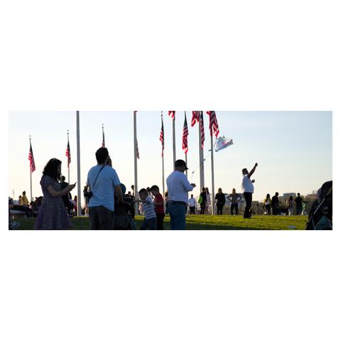 Man holding a thread to a flying kite at the Washington Memorial in Washington DC