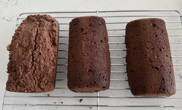 Three small loaves of pound cake on a cooling rack, one right side up, the other two upside down. They smell quite good, although this is not visible in the picture 😝