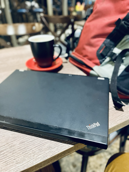 My laptop, a coffee and my backpack upon the start of my journey to ICLC2025 conference in Barcelona