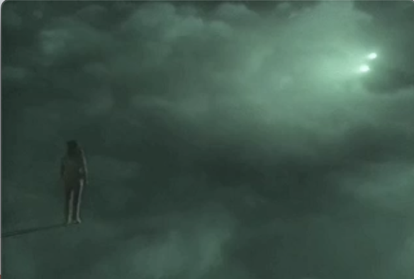 Counselor Troi stands on the precipice of a swirling, smoky green nightmare with a single point of light in the far distance shining through the green clouds.
