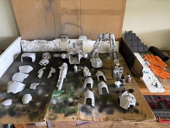 Reaver Titan pieces laid out on top of a large piece of cardboard, used as a paint station.