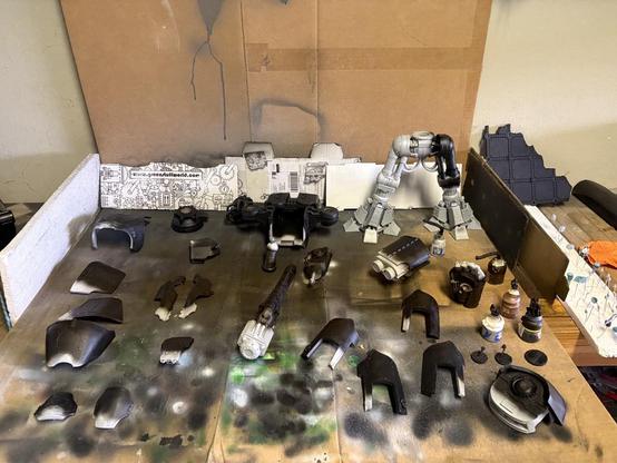 Reaver Titan pieces, laid out on cardboard used as a paint station. They are partially primed black.
