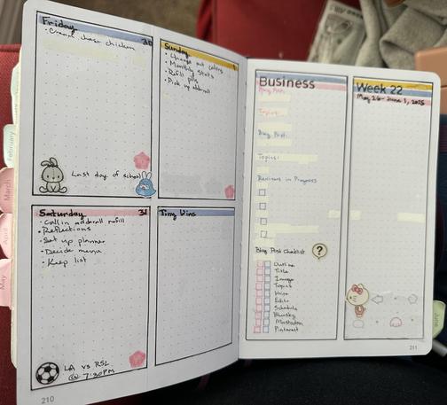 A planner spread with four boxes on page and 2 columns on the other. The four box page has Friday 30 to Sunday 1 and a box for tiny wins. There is a pink Sakura in all 3 of the days on the spread. Friday has a stuffed bunny and a bunny in a dinosaur onesie with the words last day of school. Saturday has a soccer ball with LA vs RSL @ 7:30pm. The columns page has a column for business with space for two blog posts, tracking reviews in progress and a blog post checklist that is in blue and pink and has a speech bubble with a question mark. The other column has Week 22 May 26 - June 1, 2025 and some pastel shapes on tissue paper with a black, pink, and white hello kitty sticker. The page has a header for each box or column with pink, blue, or yellow lining it."