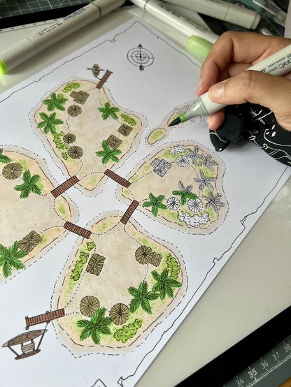 Ich koloriere gerade mit einem grünen Marker die Vegetation auf der Insel. Die Insel ist aus der Vogelperspektive gezeichnet. Man sieht Palmen und verschiedene Hütten.