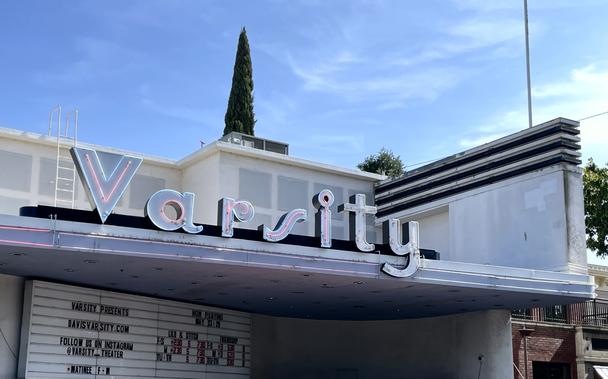 Photo of a sign, “Varsity”, on an art deco building.
