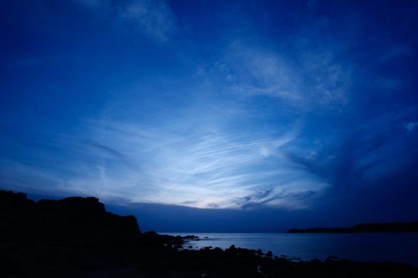 A blue sunset over a rocky coast.