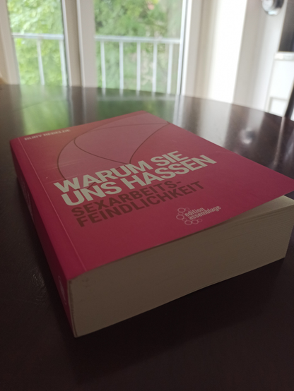 Foto vom Buch "Warum sie uns hassen - Sexarbeitsfeindlichkeit" von Ruby Rebelde. Liegt auf einem Küchentisch, der Umschlag ist Rosa
