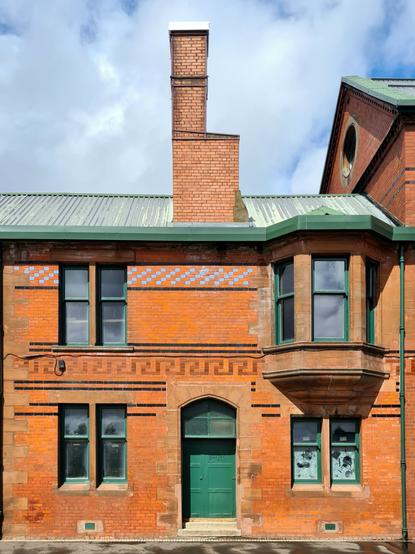 An industrial building made from red bricks and sandstone and decorated with glazed bricks.