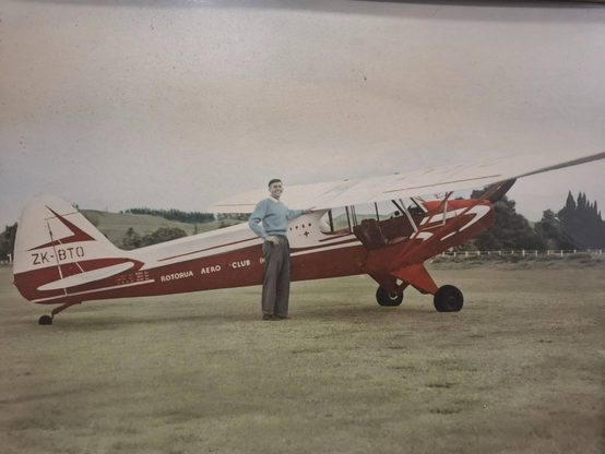 Dad standing next to to piper cup at the Rotorua aerodrome circa 1958