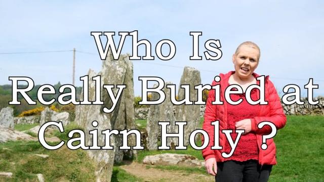 A woman in a red jacket standing in front of the megaliths of the Portal at Cairn Holy II, chambered cairn. the words 'Who Really is buried at Cairn Holy?' are overlaid on teh image.