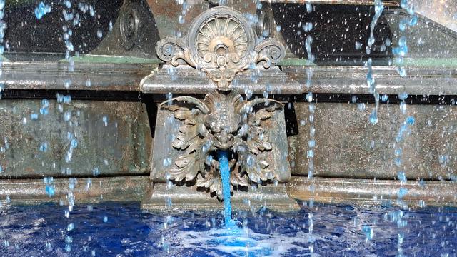 Wasserspeier mit blauer Wasserfontäne