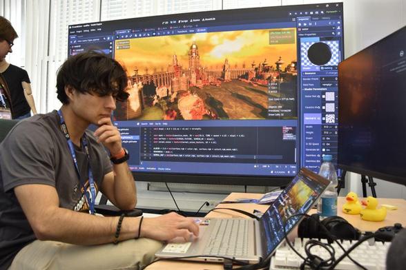 A game dev showing his environment art on a big screen which he created during the event