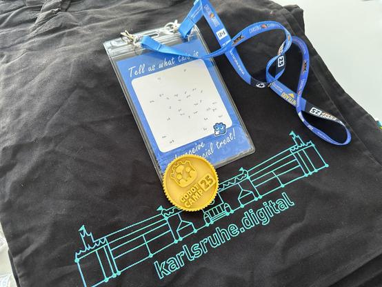 A closer look at the name badge which had a cool little puzzle on the back, a 3d printed coin with the GodotCamp logo on it and a karlsruhe.digital shirt