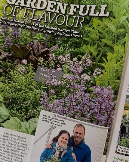 Part of a magazine article showing a herb display and the owners of the nursery.