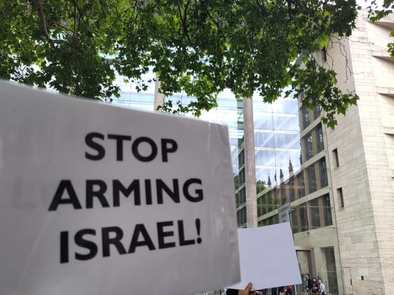 Plakat, schwarz auf weiss vor dem Auswärtigen Amt "STOP ARMING ISRAEL"