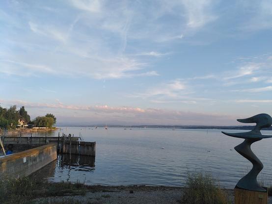 Blick auf Wasser in der Abendsonne. Ein paar Wolken am Himmel.