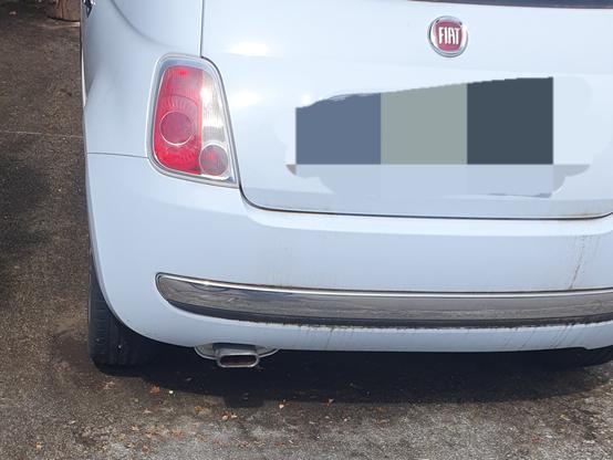 Ein Fiat 500 von hinten. Der Auspuff erinnert an einen USB-C-Anschluss.
