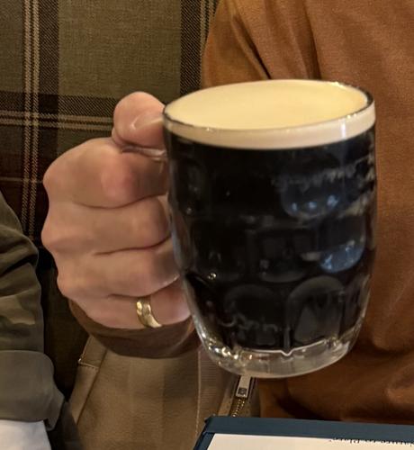 A dimpled glass full of dark beer