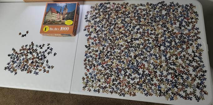 A disassembled jigsaw puzzle of a town in Bavaria, Germany, spread out on a table, ready for assembly.