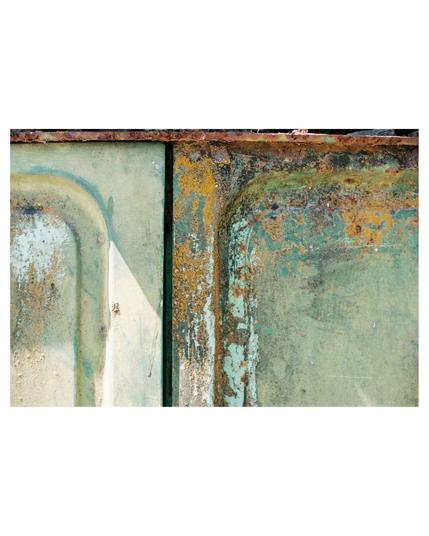 close up of the side of an old light green truck, the metal is rusty and covered with beautiful yellowish sprinkles