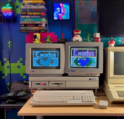 Atari 520STm system with dual monitors (mono and color) setup on a desk with a system stand, next to an Apple IIe computer