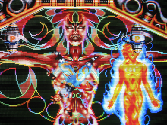 Osman performs an acrobatic flip while battling a psychedelic, occult avatar boss. Kaleidoscopic color festoons the scene.