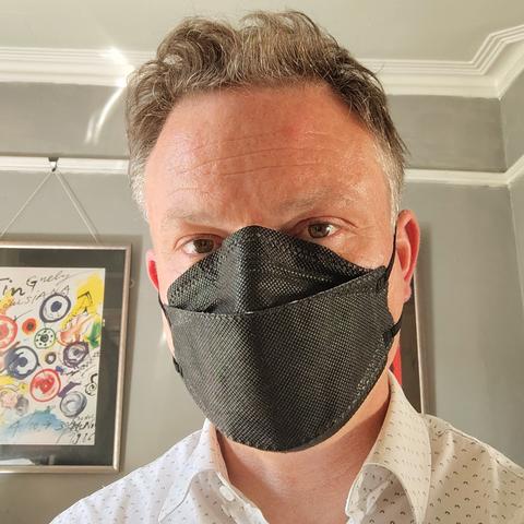 Man wearing black respirator mask.