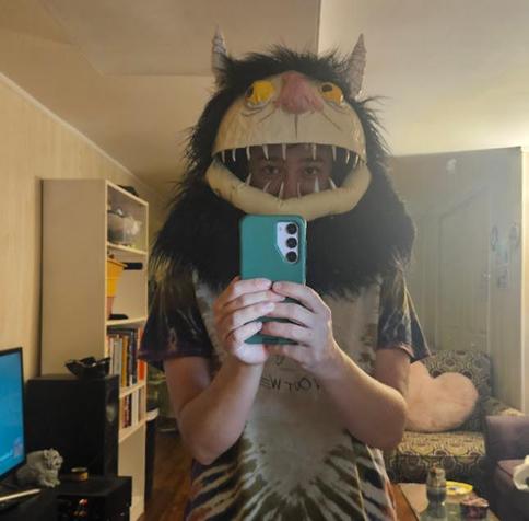 Mirror selfie of a man wearing a monster mask, with his eyes showing through the mouth.