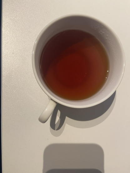 Schwarztee in einer weißen Tasse. Am Tassenboden ist eine leichte Trübung zu erkennen.