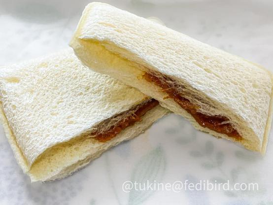 ランチパック「バターチキンカレー」の中身。白いパンが半分にカットされ、濃いオレンジ色のバターチキンカレーが見えます。