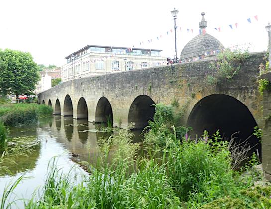 A bridge over a river, with townscape beyond.