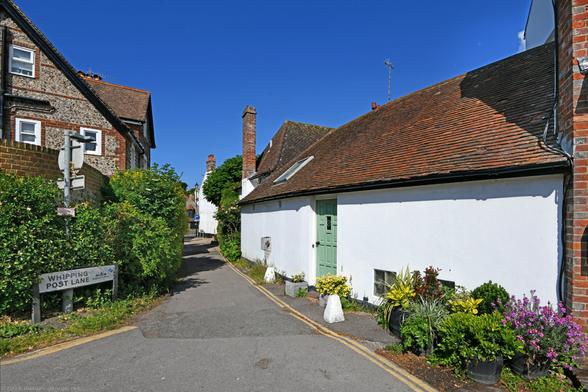 Photo of a lane in Rottingdean which records show was called East Lane until 1933. According to the Conservation Area appraisal there was once a village whipping post and stocks located nearby. Buildings date from the C18. Rottingdean, City of Brighton & Hove, UK.