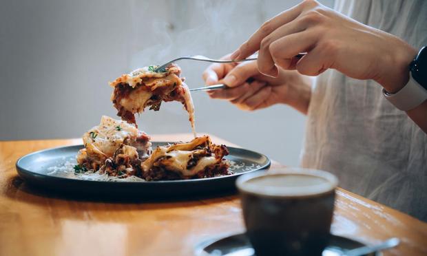 Una persona, comiendo una lasaña. (Getty Images)