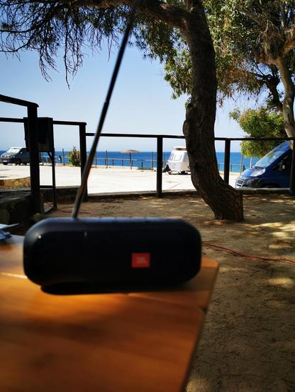 Bild zeigt einen JBL Tuner auf einem Tisch. Im Hintergrund ist Meer zu sehen