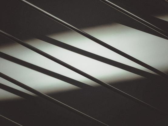 The iron elements of a handrail and their shadows on the wall.