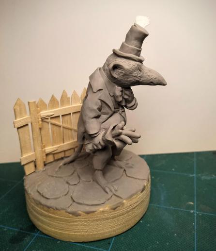Sculpture of a shrew with a hat and a worm bouquet by Victoria Maderna.
