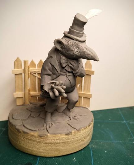 Sculpture of a shrew with a hat and a worm bouquet by Victoria Maderna.