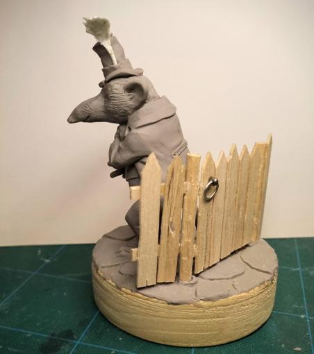 Sculpture of a shrew with a hat and a worm bouquet by Victoria Maderna.