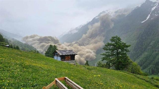 Photo de l'effondrement vu du versant opposé.
On voit un nuage marron et épais recouvrir tout le fond de la vallée.