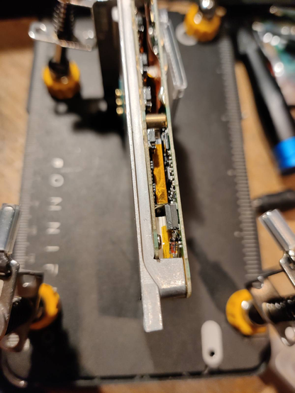 The VX8 PCB stack visible from the side. At the bottom, between the two PCBs below a black diode, a red/transparent diode in DO formfactor can be seen, which replaces the original reverse-protection diode