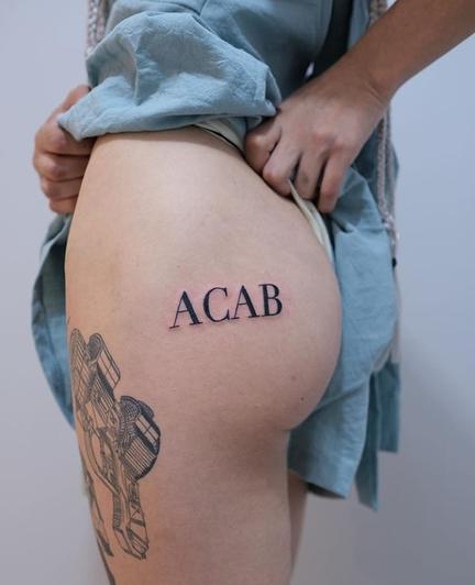 ACAB tattoo inscription on the left buttock